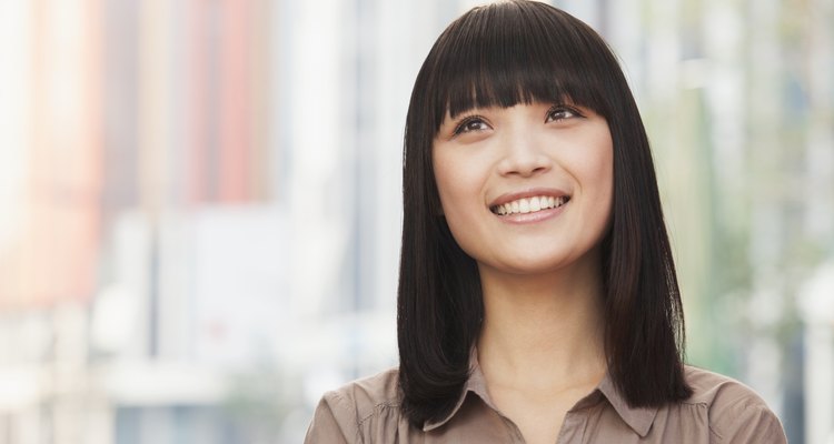 Portrait of smiling young woman outdoors in Beijing, looking up