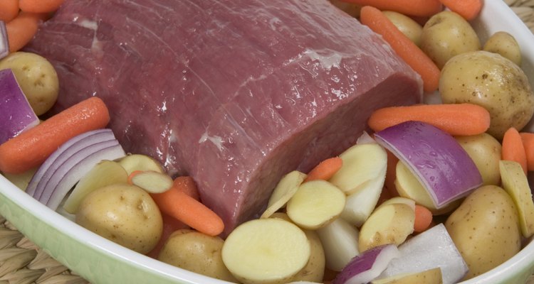 Uncooked pot roast on a bed of vegetables