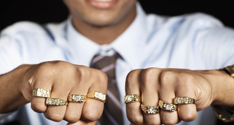 Hombre con muchos anillos de oro en los dedos.