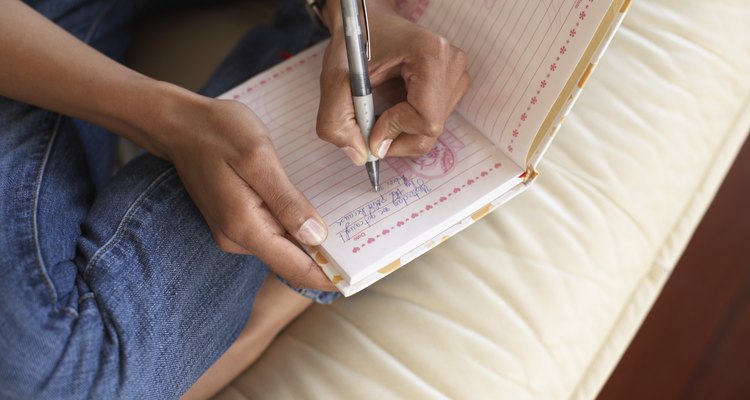 Woman's hands writing in journal