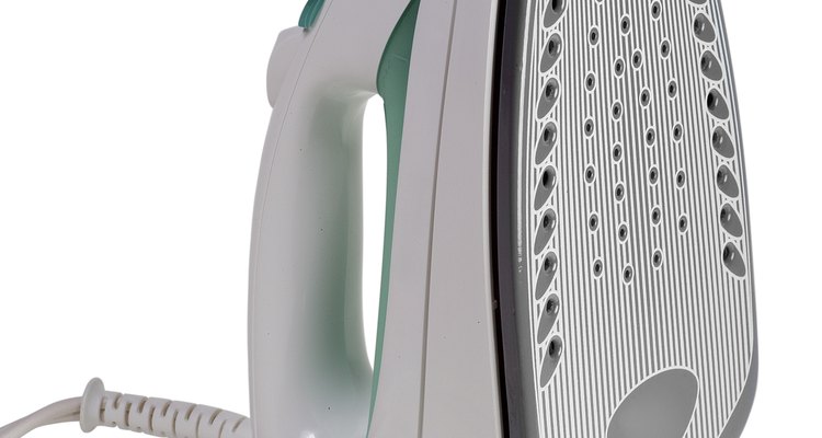A steam iron emits a small puff of steam at the push of a button.