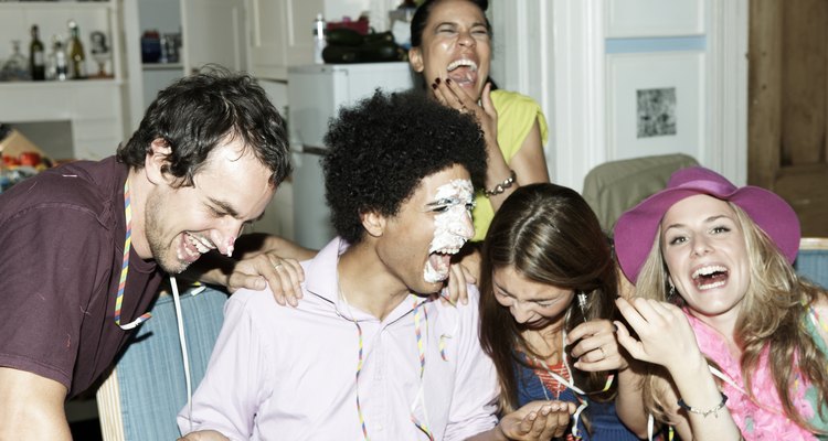 Man with icing on his face laughing with friends