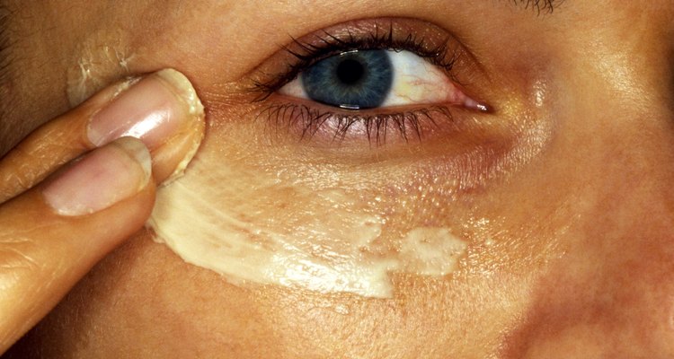 Woman applying cream under eye