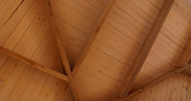 Crea un ecléctico techo de madera con paneles contrachapados y tiras decorativas con molduras.