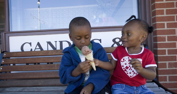 Boy and girl sharing ice cream cone