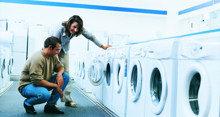 Couple Looking at a Washing Machine in An Aisle of a Department Store