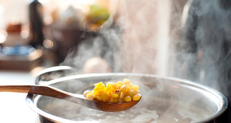 Making pea soup. Saucepan and wooden spoon with pea.