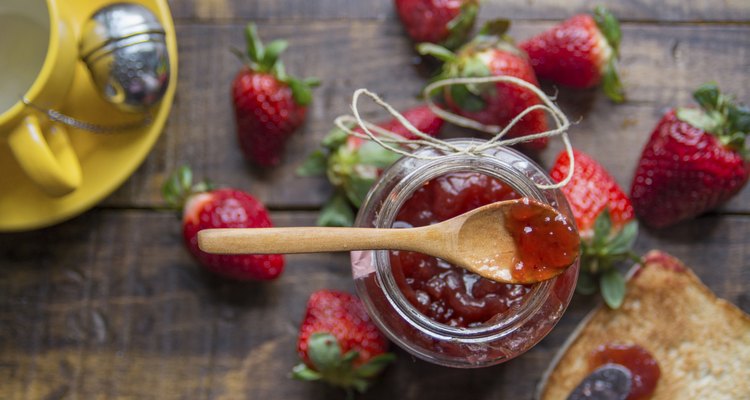 Strawberry jam, fresh strawberries on wooden background