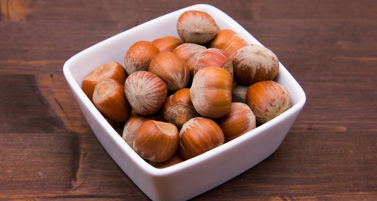 Hazelnuts on square bowl on wood