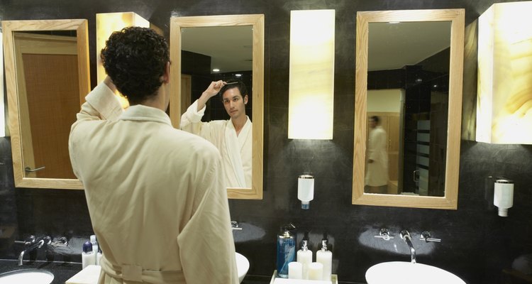 Man in robe in front of bathroom mirror