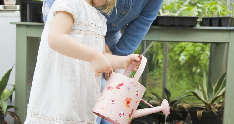 Mantente cerca de tu hijo para ayudarlo a guiarse en el proceso de plantar.