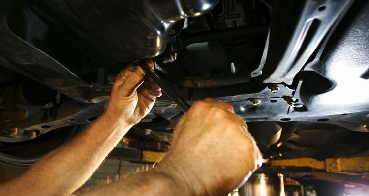 Hands of mechanic working under car