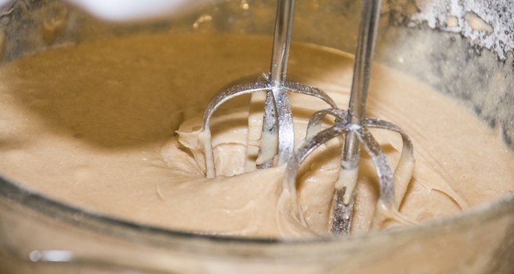 Electric mixer mixing cake mixture in a glass bowl