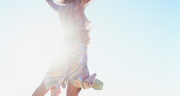 Rear View of Young Woman Jumping on the Beach