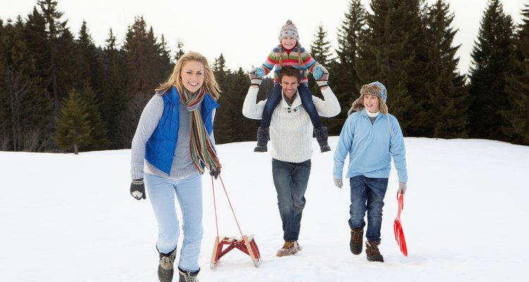 Young Family Walking Through Snow With Sled