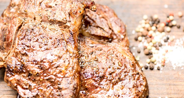 grilled steaks on an old wooden board juicy