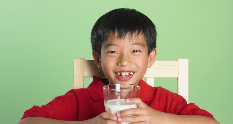 Portrait of Asian boy holding glass of milk