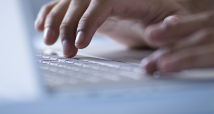 Hands typing on laptop computer, close-up