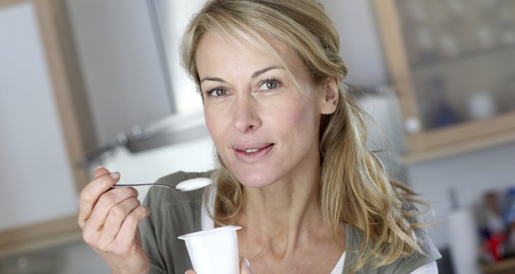 Closeup of blonde mature woman with yoghurt in hands