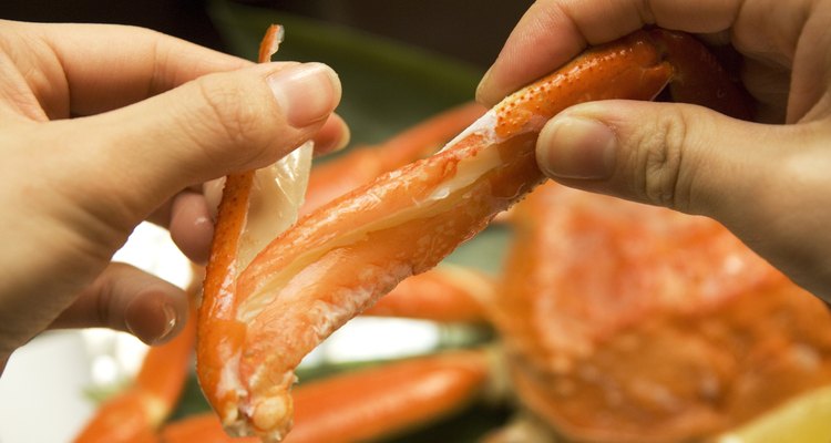 Close up of hands opening a crab shell