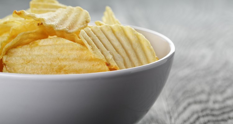 rippled organic chips in white bowl on wooden table