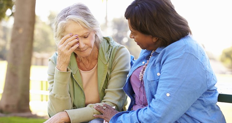 Woman Comforting Unhappy Senior Friend Outdoors