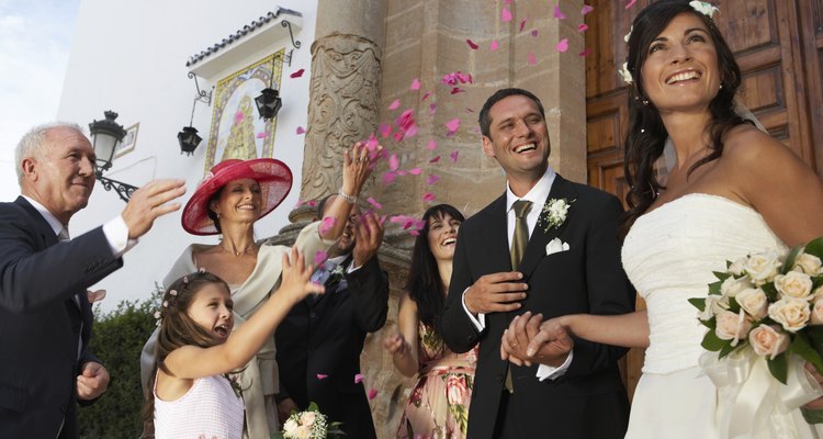 Guests throwing confetti over bride and groom, low angle view