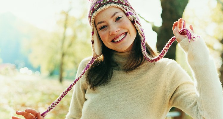 Woman Wearing Winter Clothing and Holding Woollen Hat