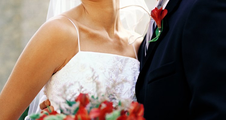 portrait of the bride and groom standing with a bouquet of flowers