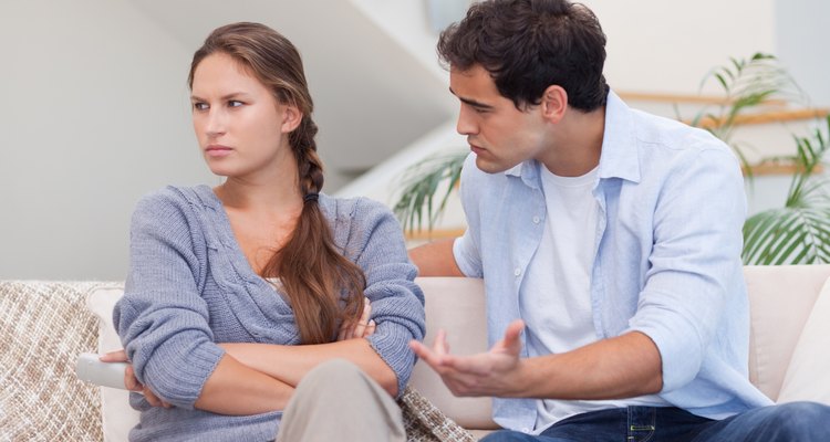 Una pareja tiene una discusión en casa en el sofá.