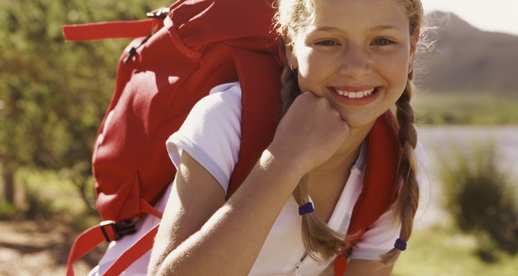 Portrait of a Girl Outdoors, Crouching Wearing a Rucksack