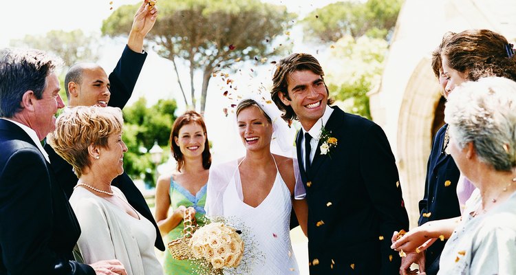 People Throwing Confetti Over a Newlywed Couple Leaving Church