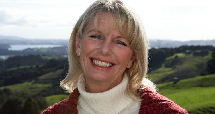 Smiling mature woman against rural landscape, portrait, head and shoulders