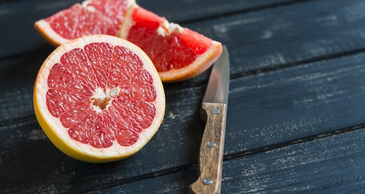 fresh sliced grapefruit on a dark wooden surface