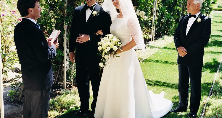 Bride and Groom With the Father at a Marriage Ceremony in a Garden