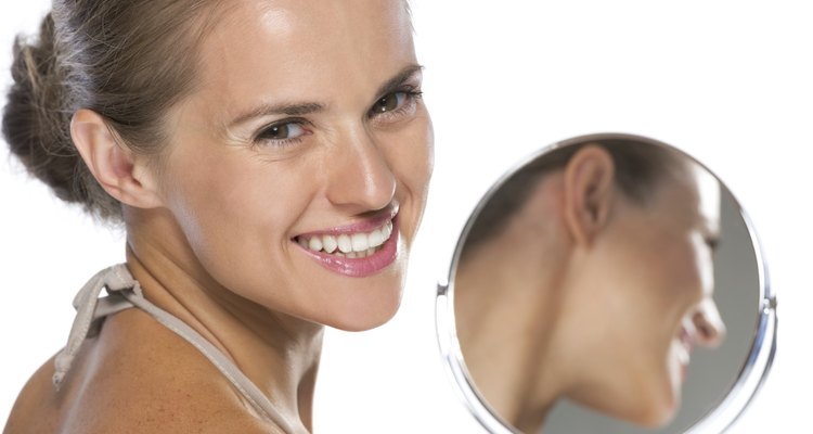 portrait of smiling young woman with mirror