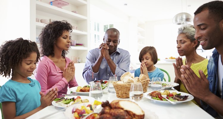 Multi Generation African American Family Praying At Home