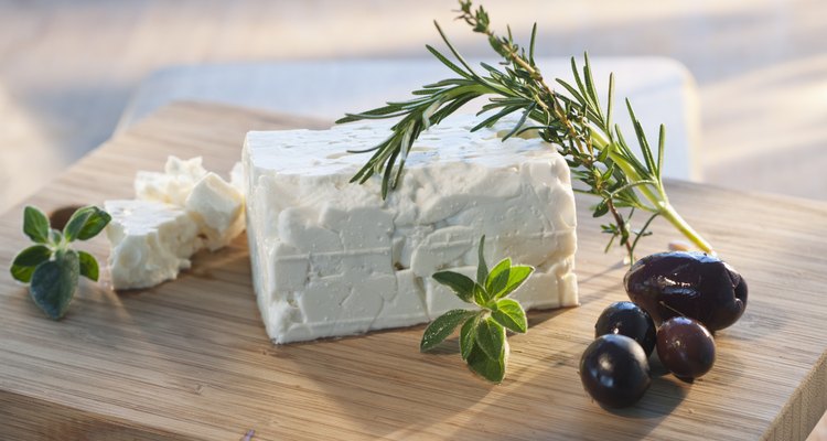 Cheese with herbs on chopping board