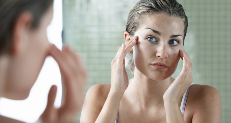 Woman Examining Herself In Front Of Mirror