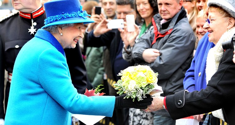 La Reina de Inglaterra recibe flores de un admirador.