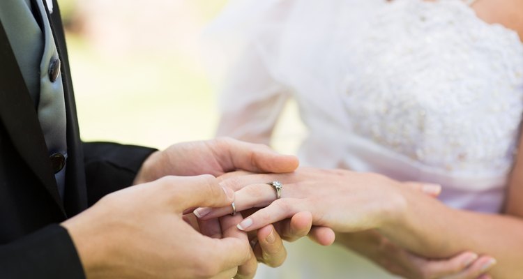 Groom placing ring on brides finger