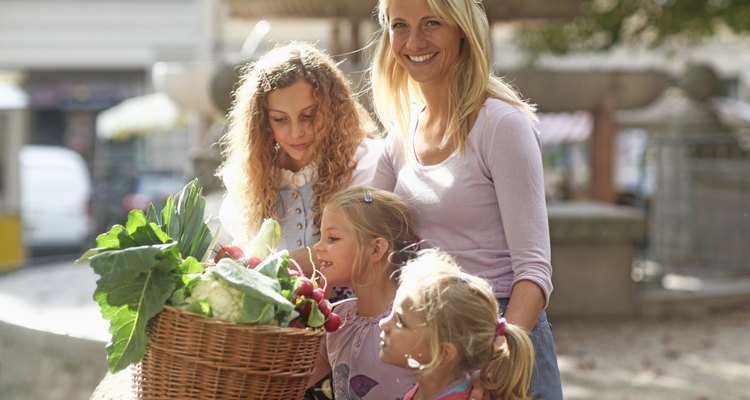 Madre comprando alimentos orgánicos con sus tres hijas.