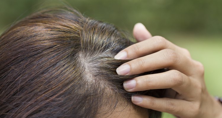 Young woman shows her gray hair roots