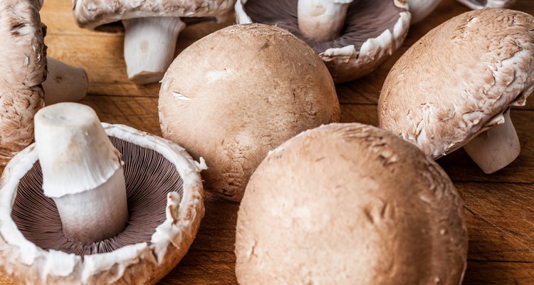 Big champignon mushrooms scattered on wooden cutting board