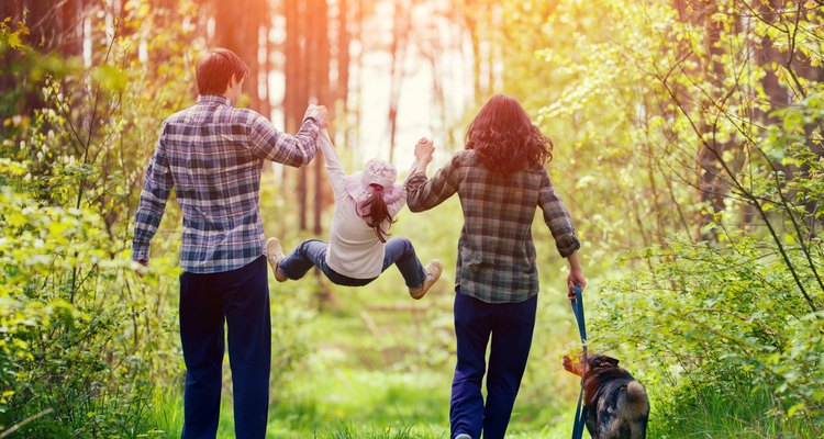 Happy family walking with dog in the forest