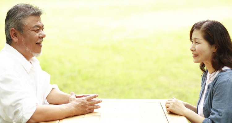Man and woman having discussion at table.