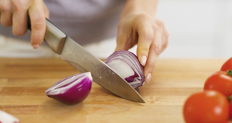 Closeup on woman cutting onion