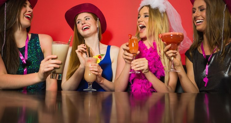 Laughing friends at a hen night drinking cocktails