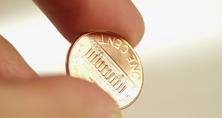 Close-up of a human hand holding a one cent coin