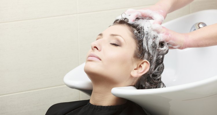 Hairstylist washing woman hair. Hairdressing beauty salon